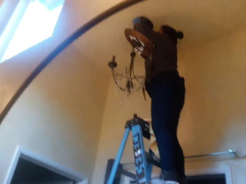Electrician installing a chandelier in a Union residence